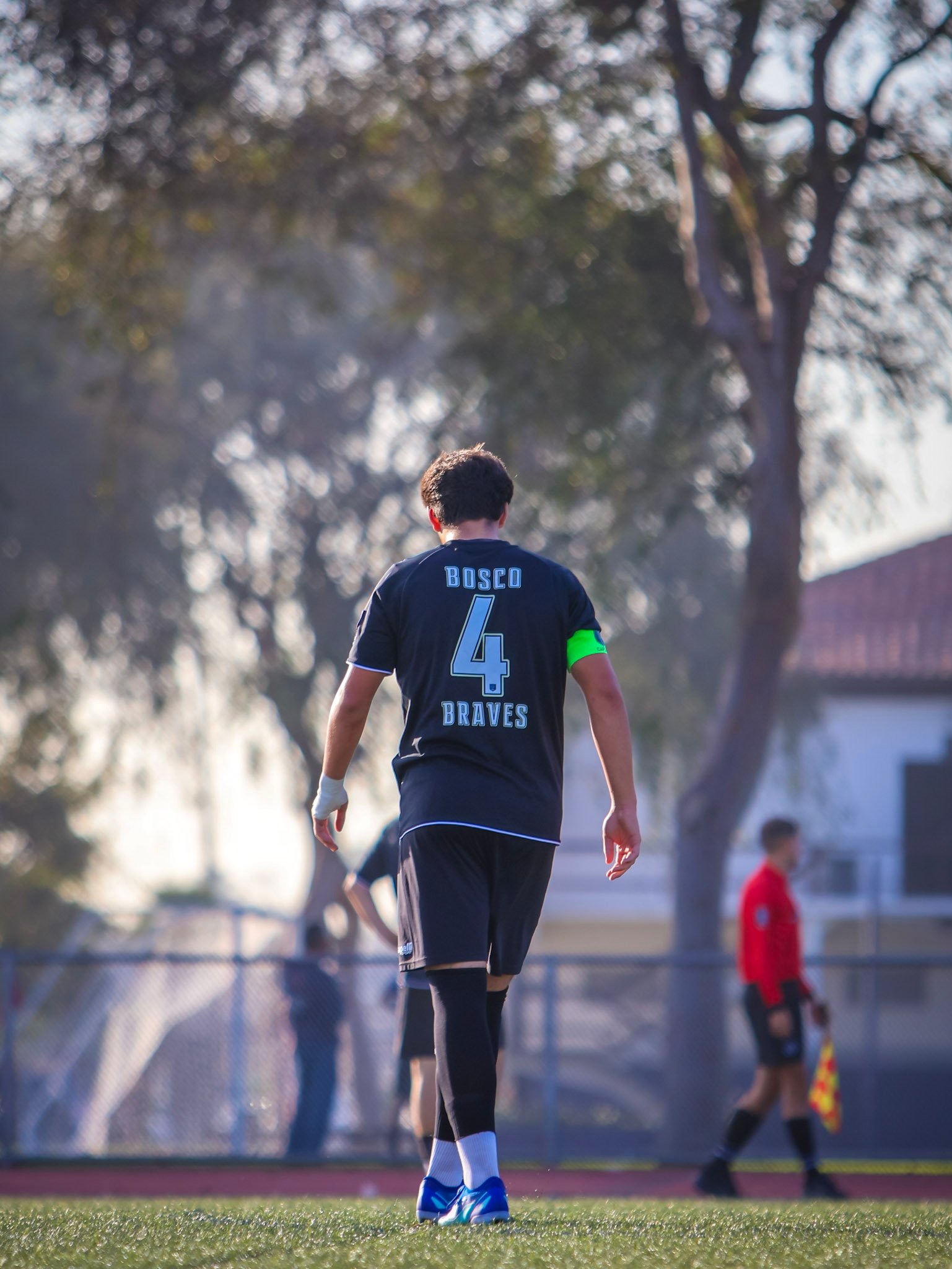 Soccer captain walking across the field in afternoon light