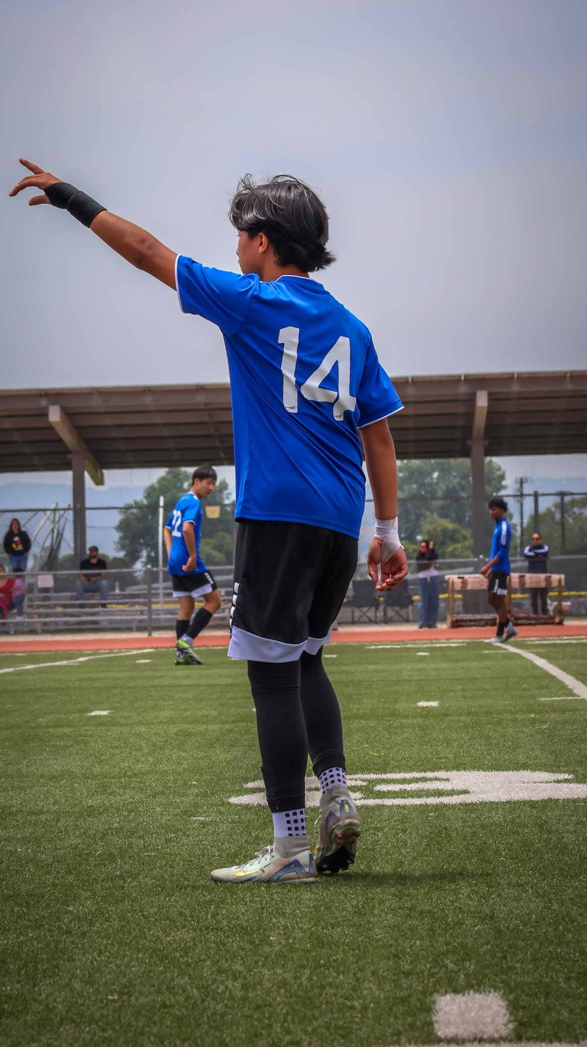 Soccer player signaling to a teammate on the field